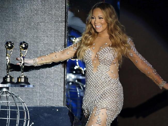 Mariah Carey and two large golden orbs. Also pictured: A couple of award statues. Picture