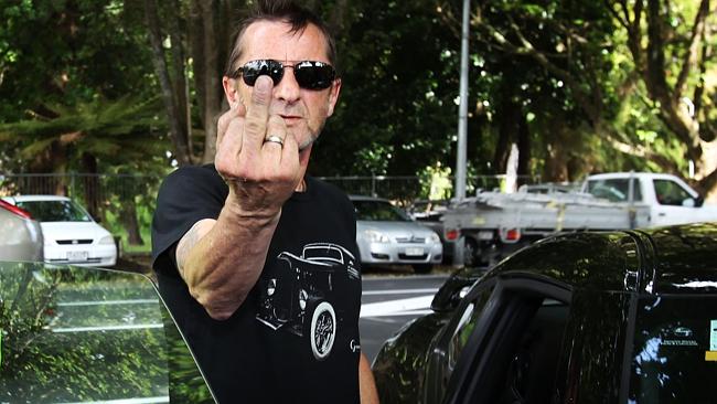 AC/DC drummer Phil Rudd gestured to the media as he left Tauranga District Court after be