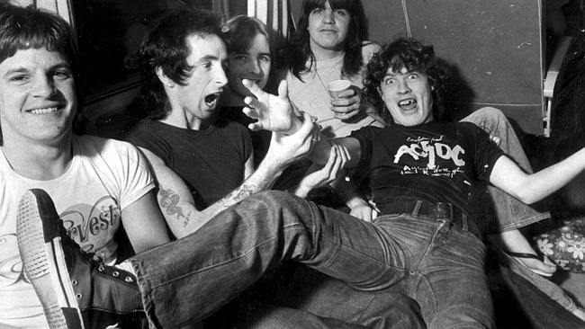ACDC on tour bus in 1976 (L-R) Mark Evans, Bon Scott, Phil Rudd, Malcolm Young & Angus Yo