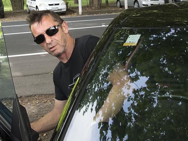 Former AC/DC drummer Phil Rudd climbs into his car as he leaves court. Picture: AFP