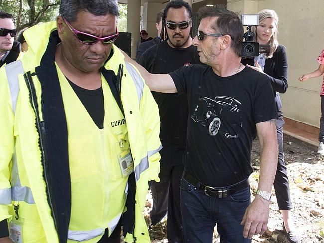 Former AC/DC drummer Phil Rudd hid behind a body guard as he left court in Tauranga, New 