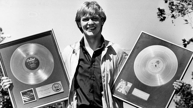 John holding two record awards he scored back in 1982.