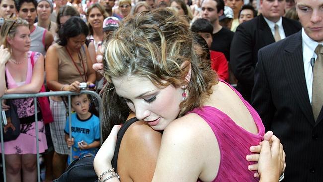 Group hug ... Delta Goodrem with Queensland fan Sami Stockton in 2005. Pic Annette Dew